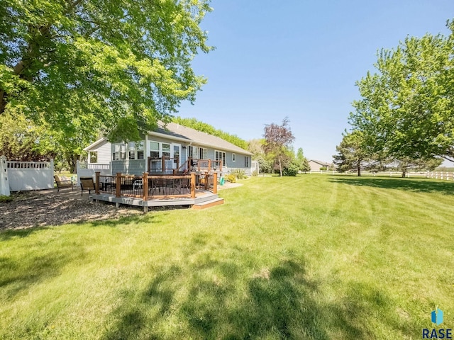 view of green lawn with a deck