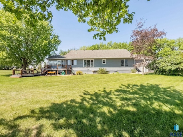 rear view of property featuring a deck and a yard