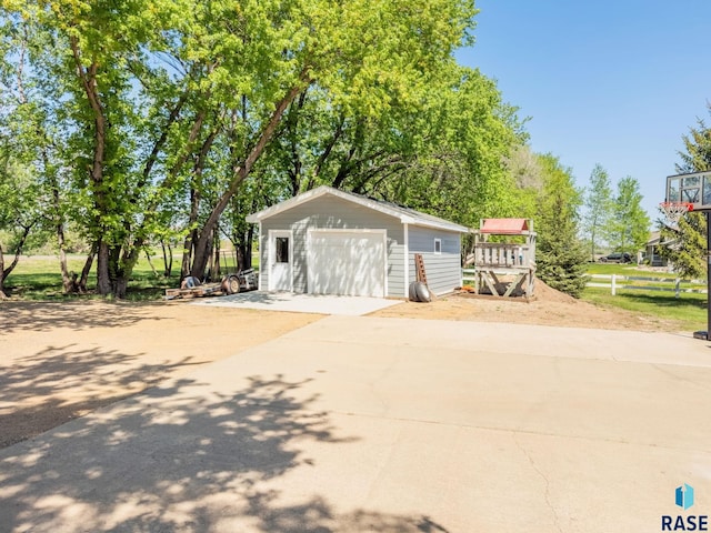 detached garage with driveway and fence