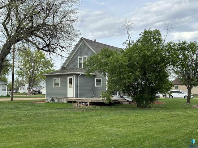 531 N Adams St, Salem, SD 57058 - back of property with a yard, a deck, and a shingled roof