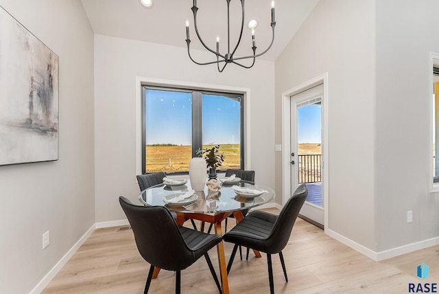 dining room with a chandelier, light wood finished floors, and baseboards
