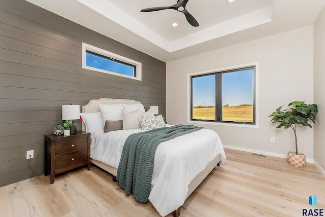 bedroom with light wood finished floors, wood walls, recessed lighting, baseboards, and ceiling fan