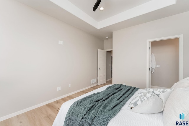 bedroom with light wood-type flooring, baseboards, and a ceiling fan