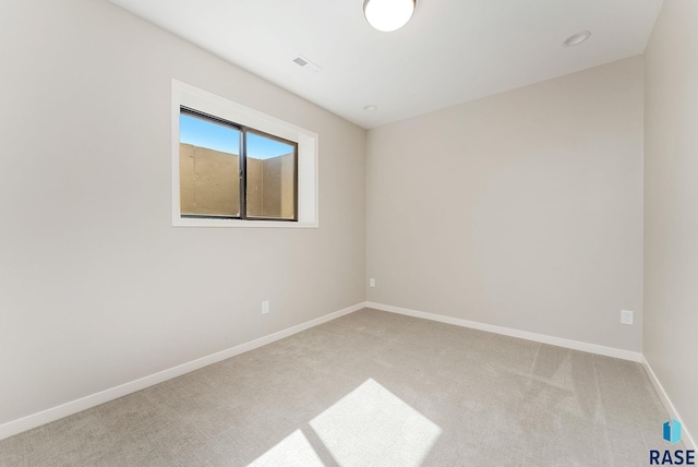 carpeted spare room featuring baseboards
