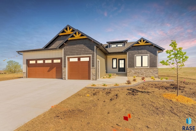 view of front facade featuring stone siding, an attached garage, and concrete driveway