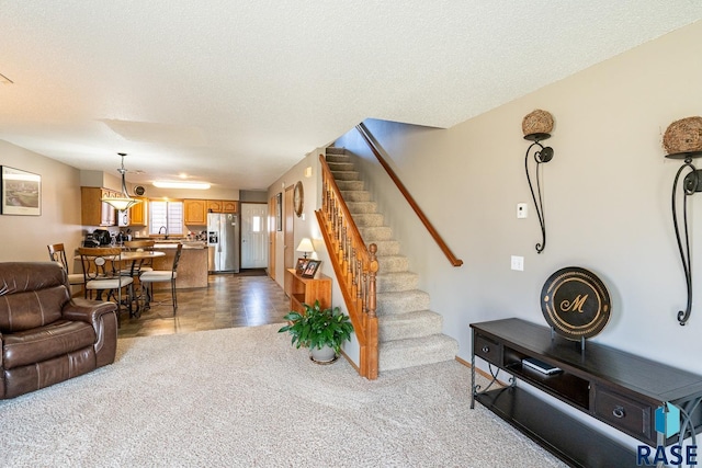 1805 S Sertoma Ave Unit 105, Sioux Falls, SD 57106 - carpeted living area with stairs, a textured ceiling, baseboards, and a sink