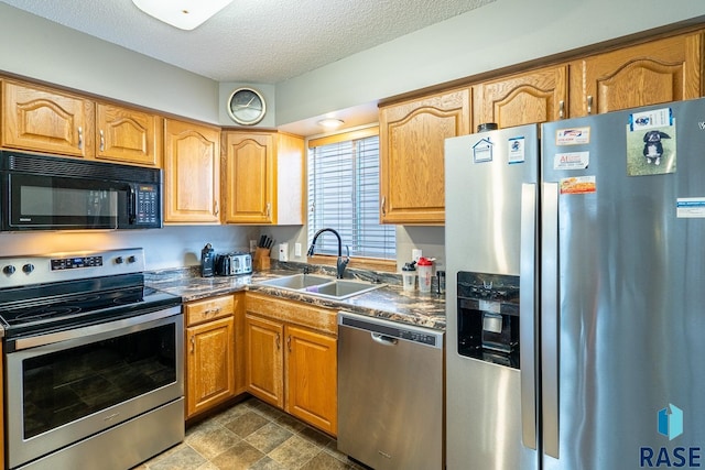 1805 S Sertoma Ave Unit 105, Sioux Falls, SD 57106 - kitchen featuring appliances with stainless steel finishes, a sink, a textured ceiling, and dark countertops