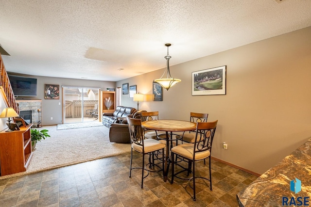 1805 S Sertoma Ave Unit 105, Sioux Falls, SD 57106 - dining area with a textured ceiling, baseboards, and a stone fireplace