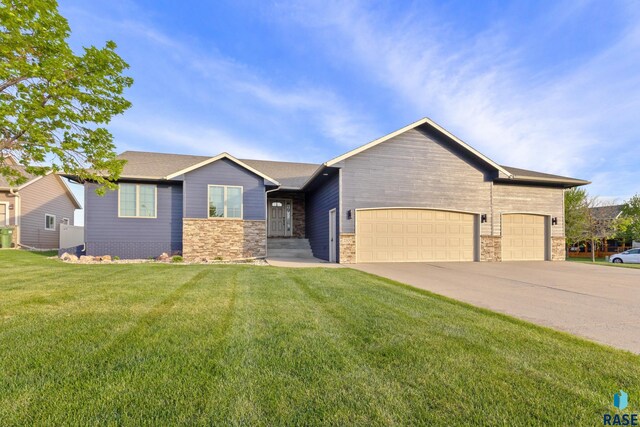 2300 Carson Cir, Tea, SD 57064 - view of front of property with stone siding, a front lawn, a garage, and concrete driveway