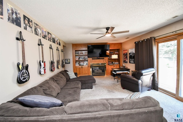 4600 S Harrington Ave, Sioux Falls, SD 57103 - carpeted living room with a textured ceiling, ceiling fan, and a glass covered fireplace