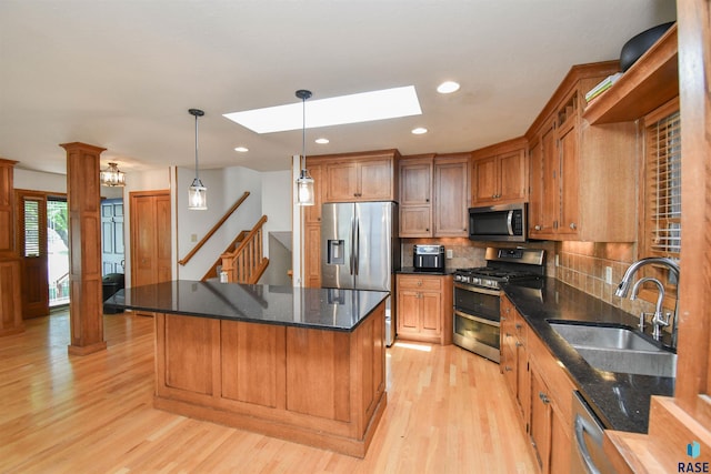 4600 S Harrington Ave, Sioux Falls, SD 57103 - kitchen with stainless steel appliances, a sink, light wood-type flooring, a center island, and tasteful backsplash
