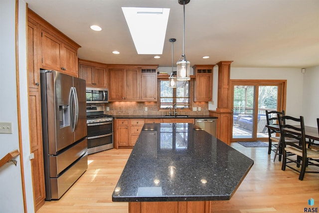 4600 S Harrington Ave, Sioux Falls, SD 57103 - kitchen featuring appliances with stainless steel finishes, light wood-style floors, tasteful backsplash, a sink, and recessed lighting