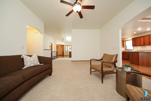 5223 E Pop Fly Pl, Sioux Falls, SD 57110 - living area with arched walkways, ceiling fan, and light carpet