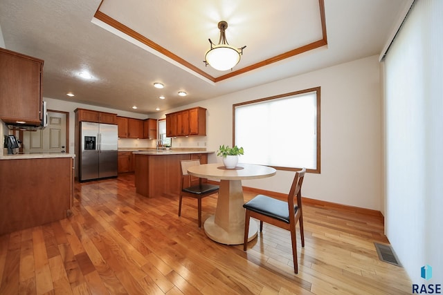 5223 E Pop Fly Pl, Sioux Falls, SD 57110 - dining space with a raised ceiling, light wood-style flooring, recessed lighting, and baseboards
