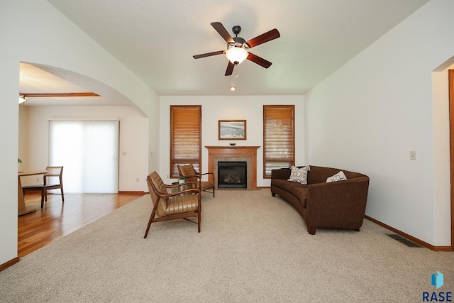 5223 E Pop Fly Pl, Sioux Falls, SD 57110 - carpeted living room with arched walkways, ceiling fan, a fireplace, and baseboards
