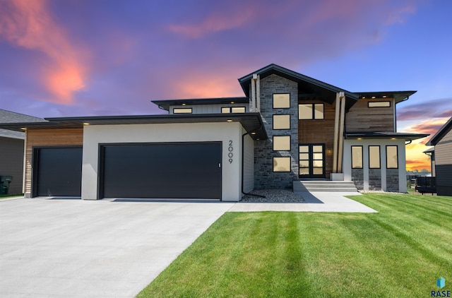 2009 S Firestone Ln, Sioux Falls, SD 57110 - contemporary house featuring an attached garage, driveway, a lawn, stone siding, and stucco siding