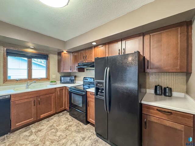 120 S Yellowstone Dr, Brandon, SD 57005 - kitchen with black appliances, under cabinet range hood, a sink, backsplash, and light countertops