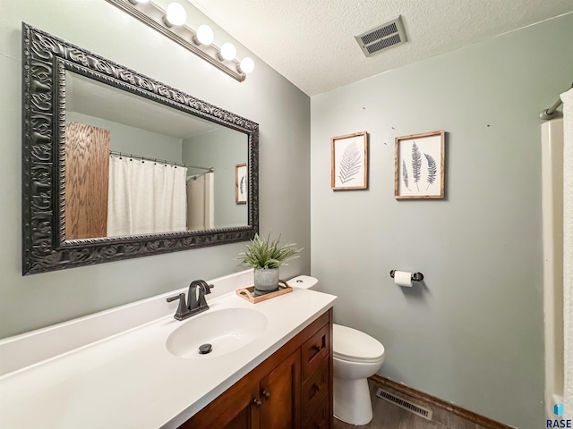 120 S Yellowstone Dr, Brandon, SD 57005 - bathroom with vanity, toilet, wood finished floors, a textured ceiling, and baseboards