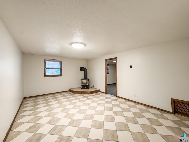 120 S Yellowstone Dr, Brandon, SD 57005 - empty room with a wood stove, a textured ceiling, and baseboards
