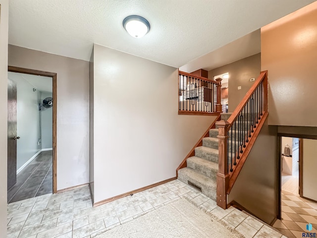 120 S Yellowstone Dr, Brandon, SD 57005 - staircase featuring a textured ceiling, tile patterned flooring, and baseboards