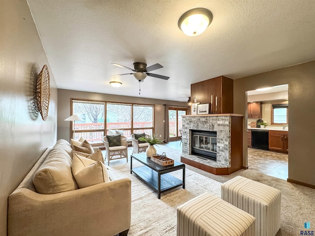 120 S Yellowstone Dr, Brandon, SD 57005 - living area featuring ceiling fan, a textured ceiling, a glass covered fireplace, baseboards, and light carpet