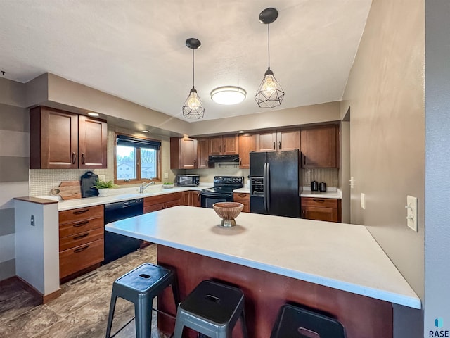 120 S Yellowstone Dr, Brandon, SD 57005 - kitchen featuring black appliances, a breakfast bar area, light countertops, and decorative backsplash