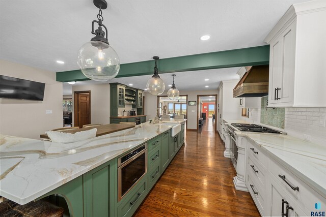 48190 265th St, Brandon, SD 57005 - kitchen with green cabinets, a sink, wall chimney range hood, white cabinetry, and tasteful backsplash