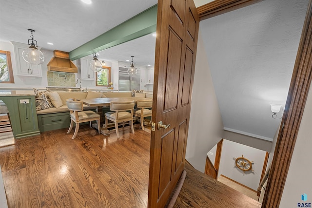 48190 265th St, Brandon, SD 57005 - kitchen with green cabinetry, custom exhaust hood, wood finished floors, white cabinetry, and decorative backsplash