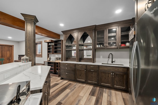 48190 265th St, Brandon, SD 57005 - kitchen featuring freestanding refrigerator, a sink, decorative columns, dark brown cabinets, and light wood-style floors