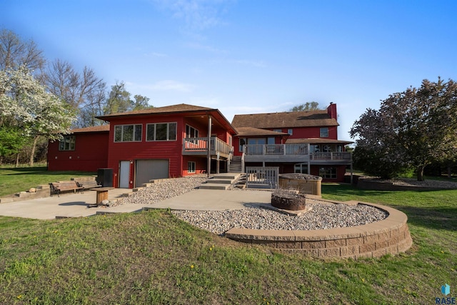 48190 265th St, Brandon, SD 57005 - rear view of house with an attached garage, a patio, concrete driveway, stairs, and a yard