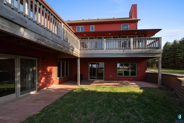 48190 265th St, Brandon, SD 57005 - rear view of house with a patio, a chimney, a lawn, and a balcony