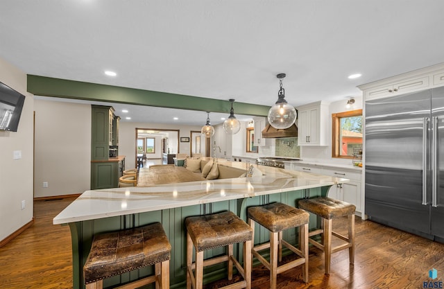 48190 265th St, Brandon, SD 57005 - kitchen featuring stainless steel built in refrigerator, green cabinetry, dark wood-style floors, a breakfast bar area, and recessed lighting