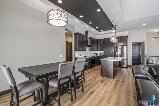 8209 E Ladyslipper Cir, Sioux Falls, SD 57110 - kitchen with stainless steel fridge with ice dispenser, electric range, open floor plan, light countertops, and dark brown cabinetry