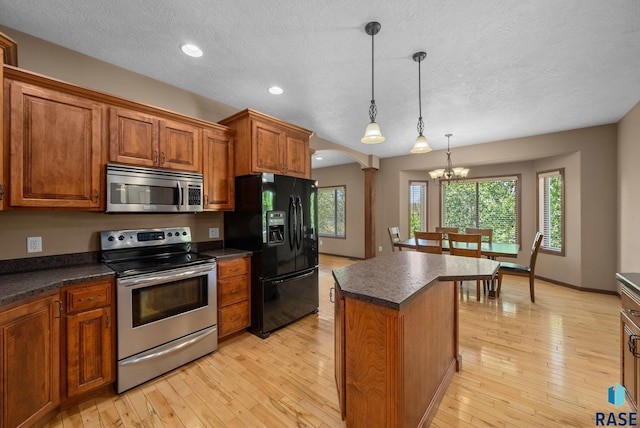 2305 N Ivy Rd, Tea, SD 57064 - kitchen with appliances with stainless steel finishes, dark countertops, a textured ceiling, a chandelier, and light wood-type flooring