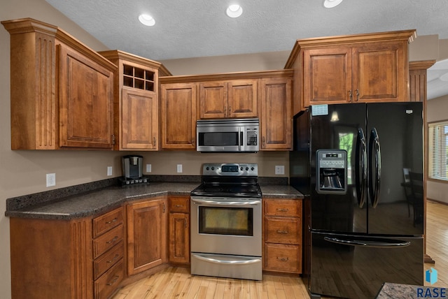 2305 N Ivy Rd, Tea, SD 57064 - kitchen featuring appliances with stainless steel finishes, light wood-style floors, dark countertops, recessed lighting, and a textured ceiling