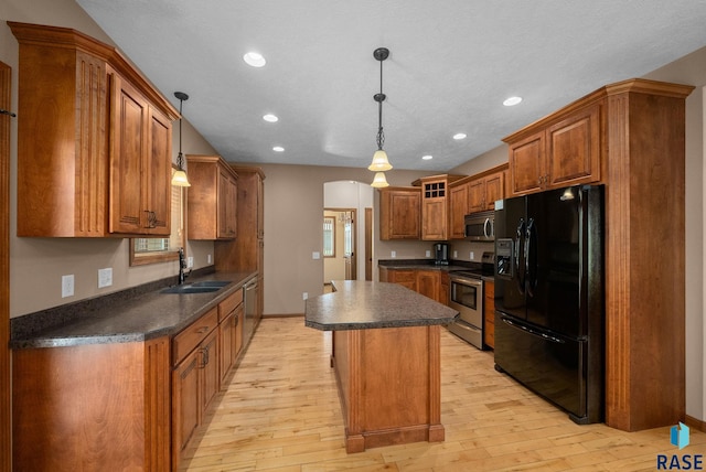 2305 N Ivy Rd, Tea, SD 57064 - kitchen with appliances with stainless steel finishes, dark countertops, a sink, brown cabinets, and light wood-style floors