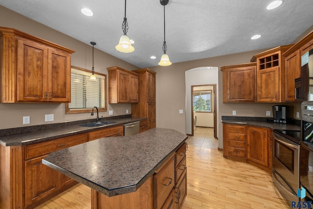 2305 N Ivy Rd, Tea, SD 57064 - kitchen featuring a sink, appliances with stainless steel finishes, dark countertops, a center island, and a textured ceiling