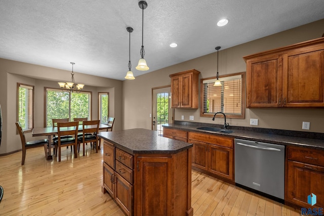 2305 N Ivy Rd, Tea, SD 57064 - kitchen featuring stainless steel dishwasher, a sink, a textured ceiling, dark countertops, and light wood-style flooring