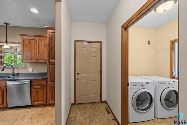 2305 N Ivy Rd, Tea, SD 57064 - washroom with separate washer and dryer, baseboards, and a textured ceiling