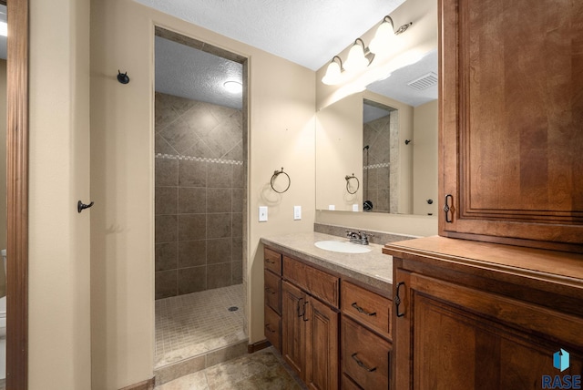 2305 N Ivy Rd, Tea, SD 57064 - bathroom featuring tiled shower, vanity, and a textured ceiling