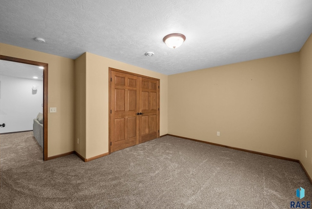 2305 N Ivy Rd, Tea, SD 57064 - unfurnished bedroom with carpet floors, a closet, baseboards, and a textured ceiling
