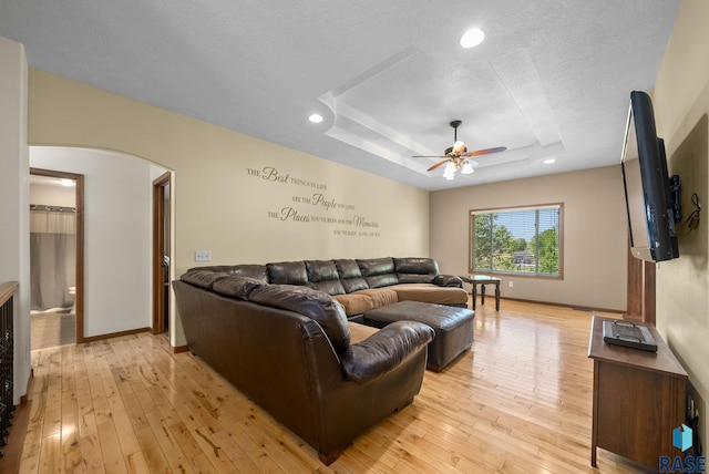 2305 N Ivy Rd, Tea, SD 57064 - living area featuring arched walkways, ceiling fan, light wood finished floors, a tray ceiling, and baseboards