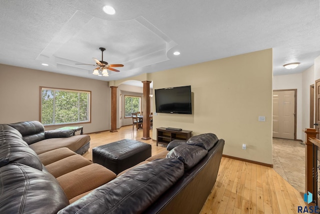 2305 N Ivy Rd, Tea, SD 57064 - living room featuring decorative columns, light wood finished floors, baseboards, a ceiling fan, and a textured ceiling