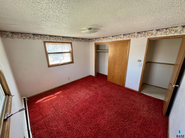 unfurnished bedroom with a textured ceiling, carpet floors, and a closet