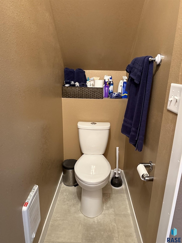 half bathroom featuring baseboards, toilet, and tile patterned flooring