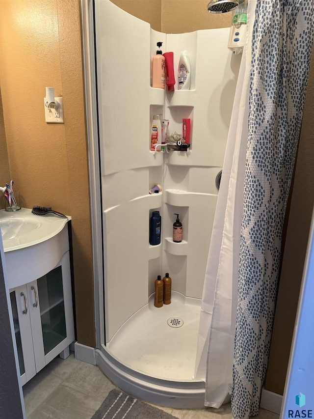 full bathroom featuring a stall shower and a textured wall