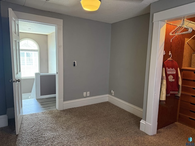 hallway with carpet floors and baseboards