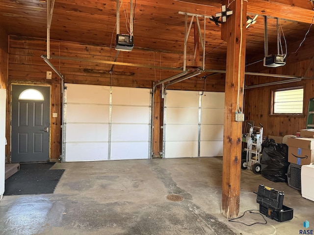 garage featuring a garage door opener and wood walls