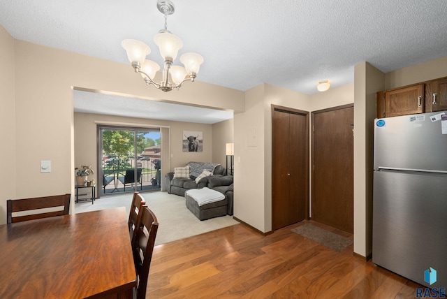 3600 S Gateway Blvd Unit 201, Sioux Falls, SD 57106 - dining space featuring a chandelier, light wood-type flooring, and a textured ceiling
