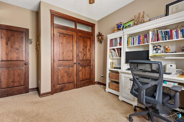 office area featuring light carpet and baseboards
